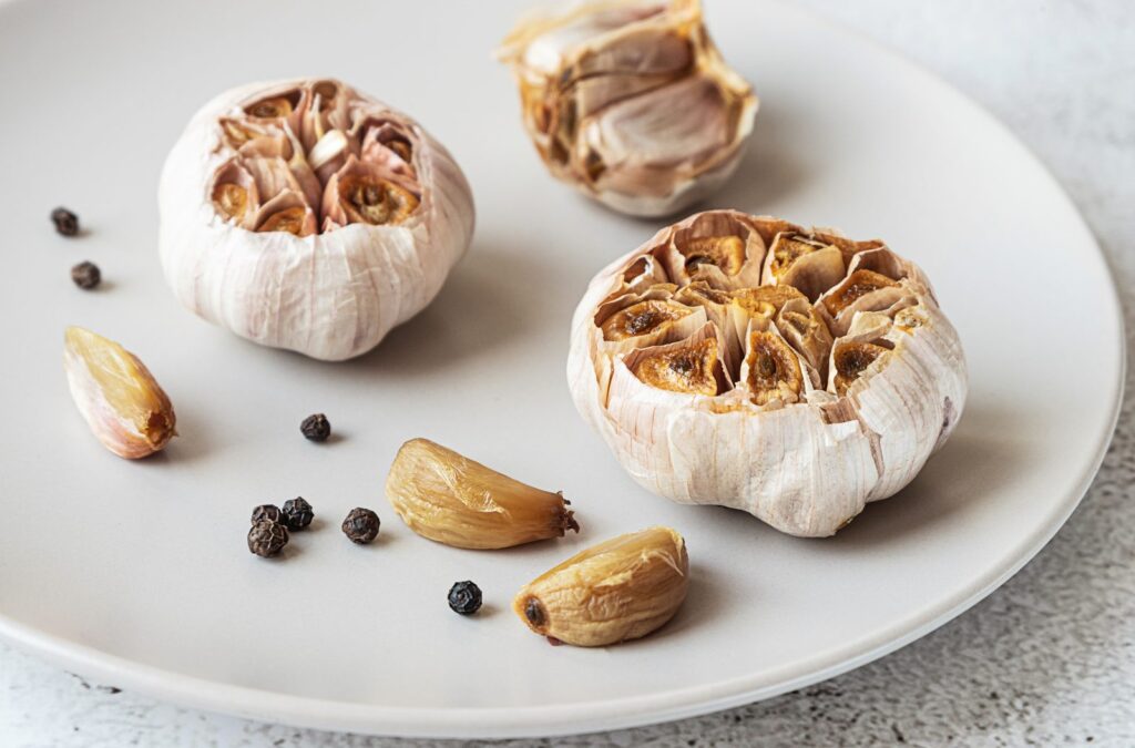 Oven-roasted garlic in its skin on a grey plate