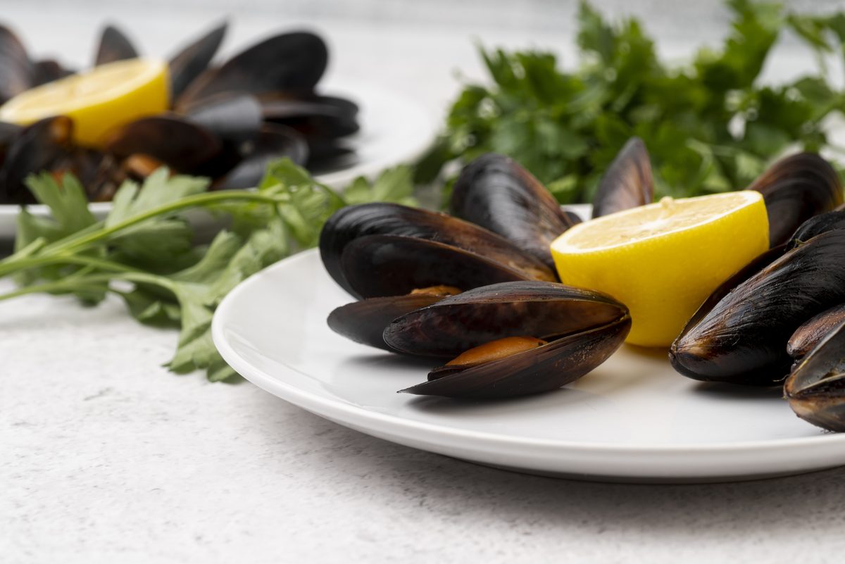 Plate of fresh mussels with lemon and parsley