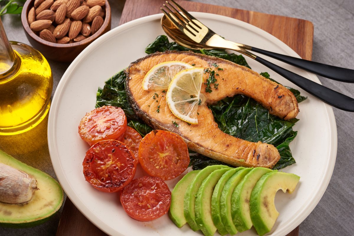 Balanced plate of grilled salmon, green salad, tomatoes and avocado