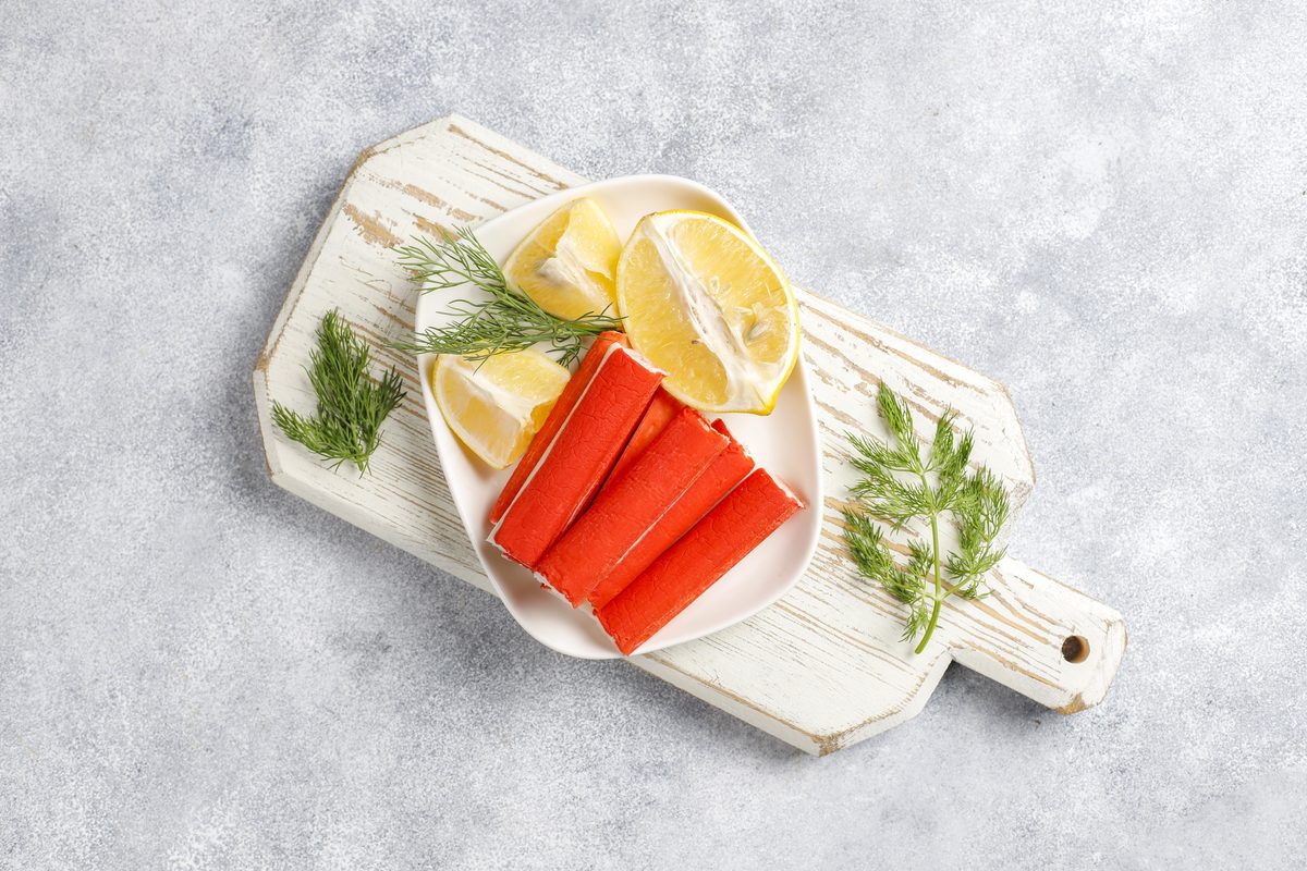 Surimi sticks served with lemon slices and dill