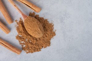 Bâtons de cannelle et cannelle en poudre dans une cuillère en bois