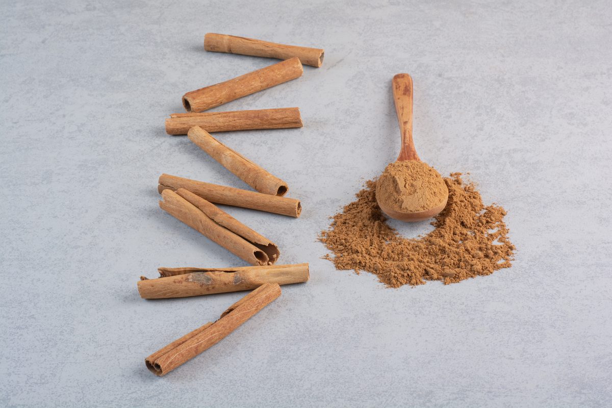 Cinnamon sticks and ground cinnamon in a wooden spoon