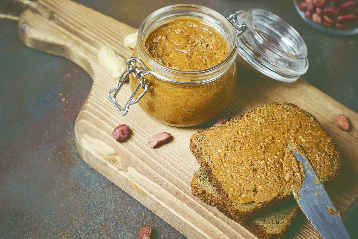Jar of peanut butter and slices of wholemeal bread