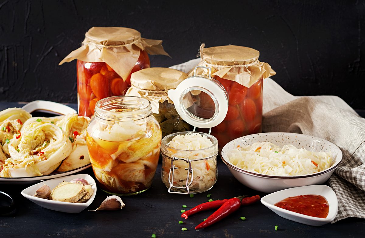 Bocaux de chou lacto-fermenté, kimchi et légumes marinés sur une table sombre