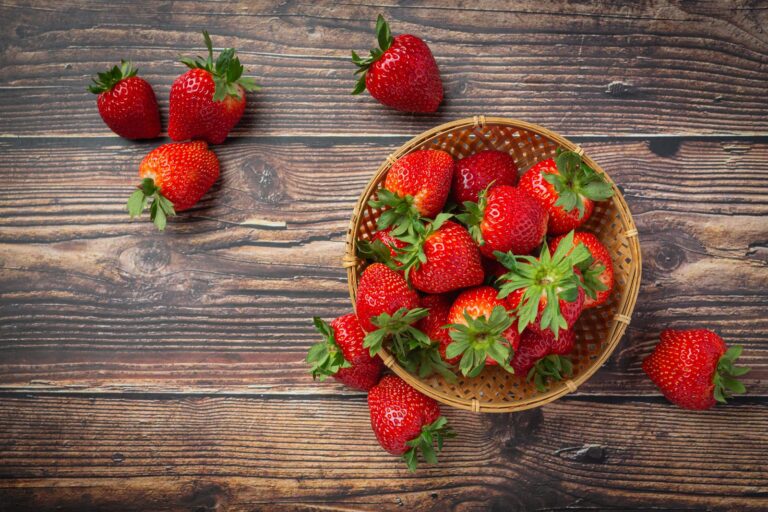 Bowl of fresh strawberries on a wooden table