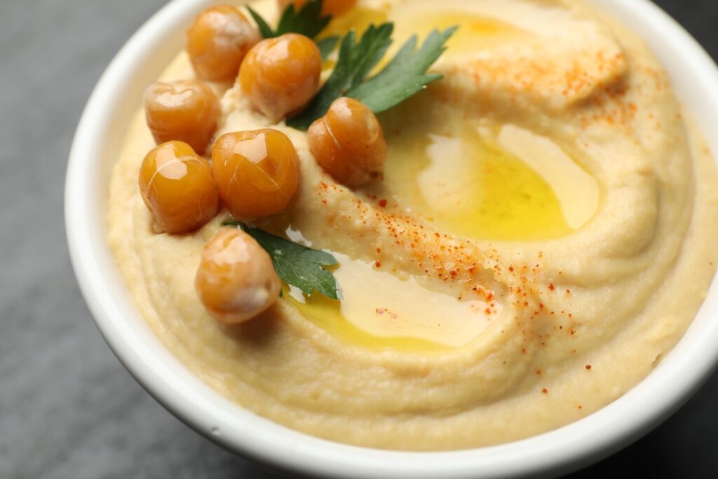 Bowl of hummus with olive oil, chickpeas and parsley