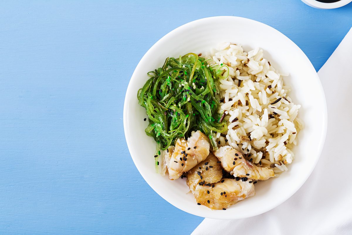 Bol de riz blanc, poisson et salade d'algues