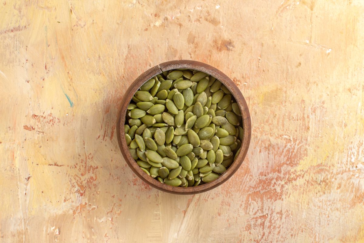 Wooden bowl filled with shelled pumpkin seeds