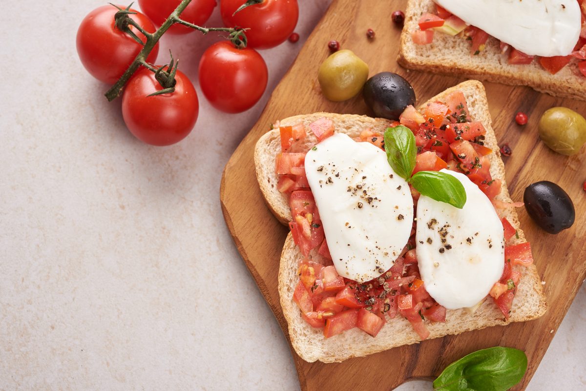 Bruschetta with tomatoes and mozzarella on a wooden board