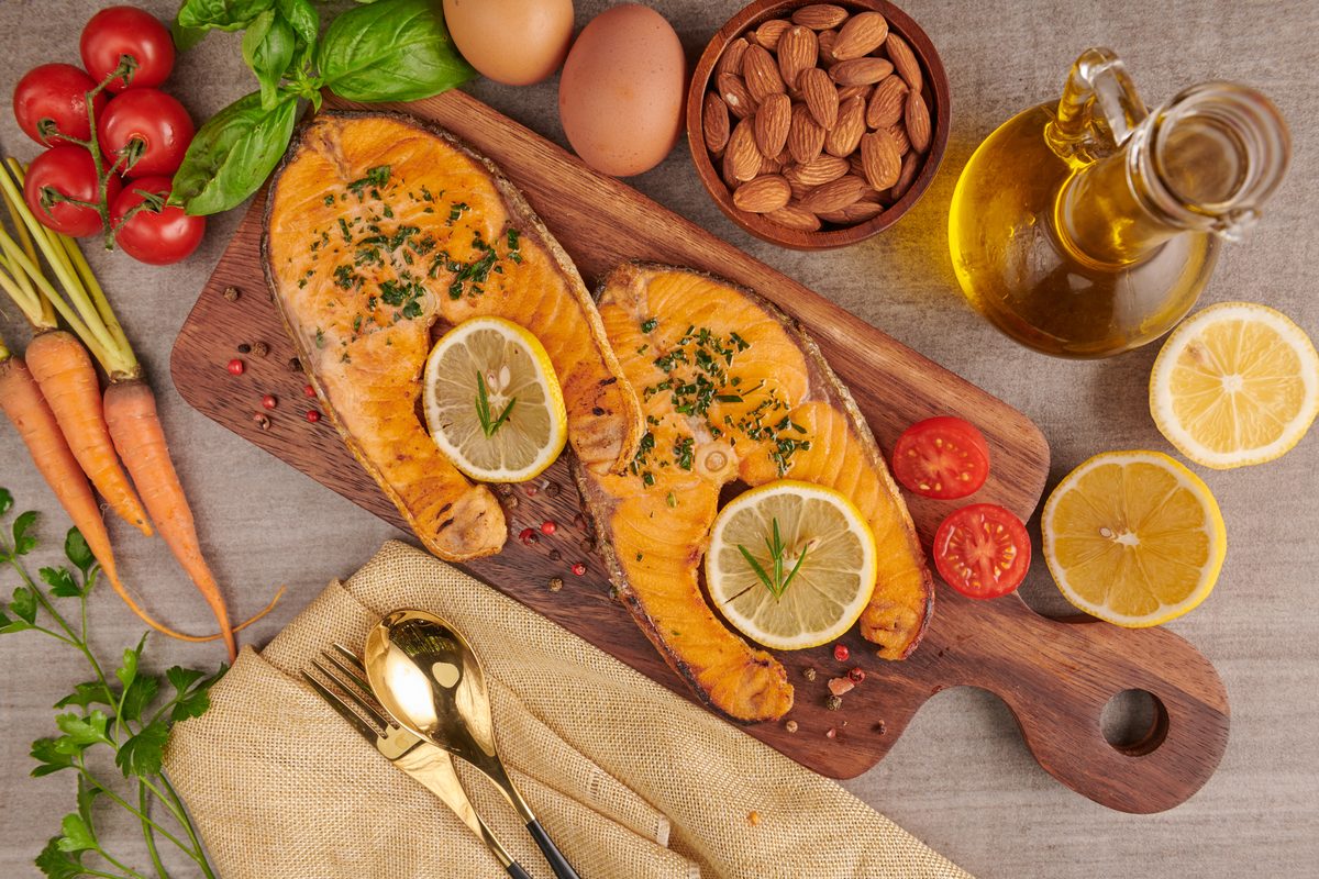 Darnes de saumon grillées au citron, amandes et œufs sur une planche en bois