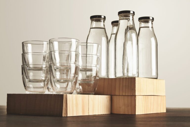 Water in glass bottles and glasses on a wooden table