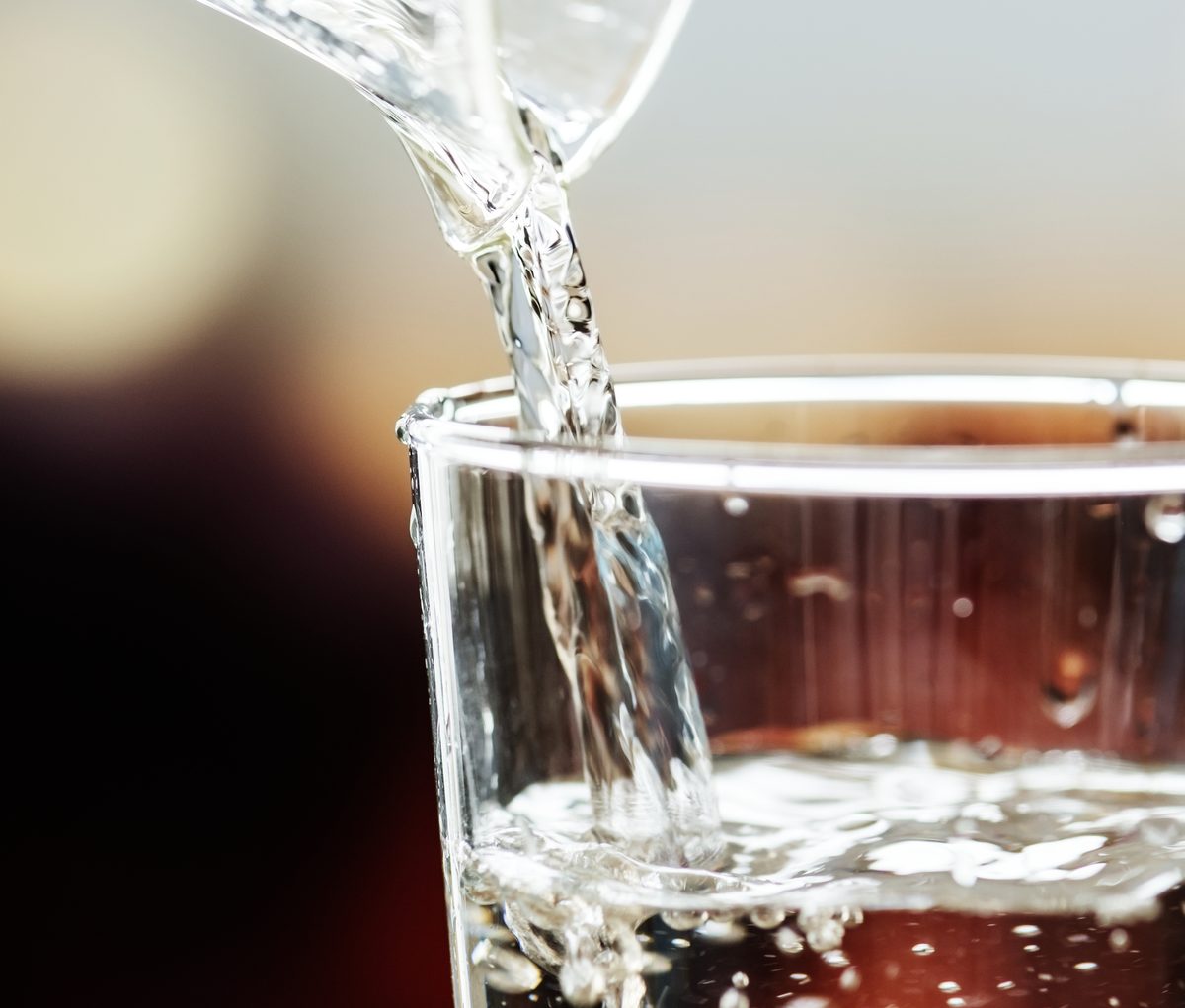 Eau versée dans un verre en gros plan