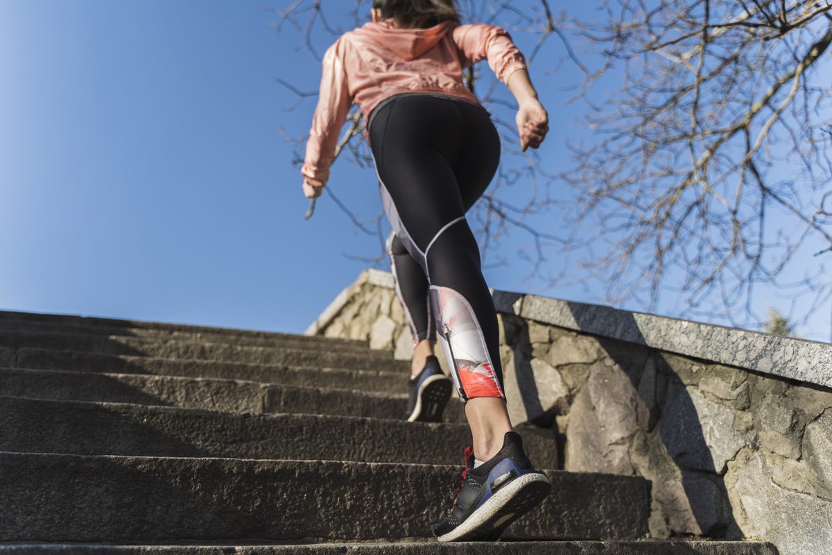 Woman in sportswear climbing outdoor steps