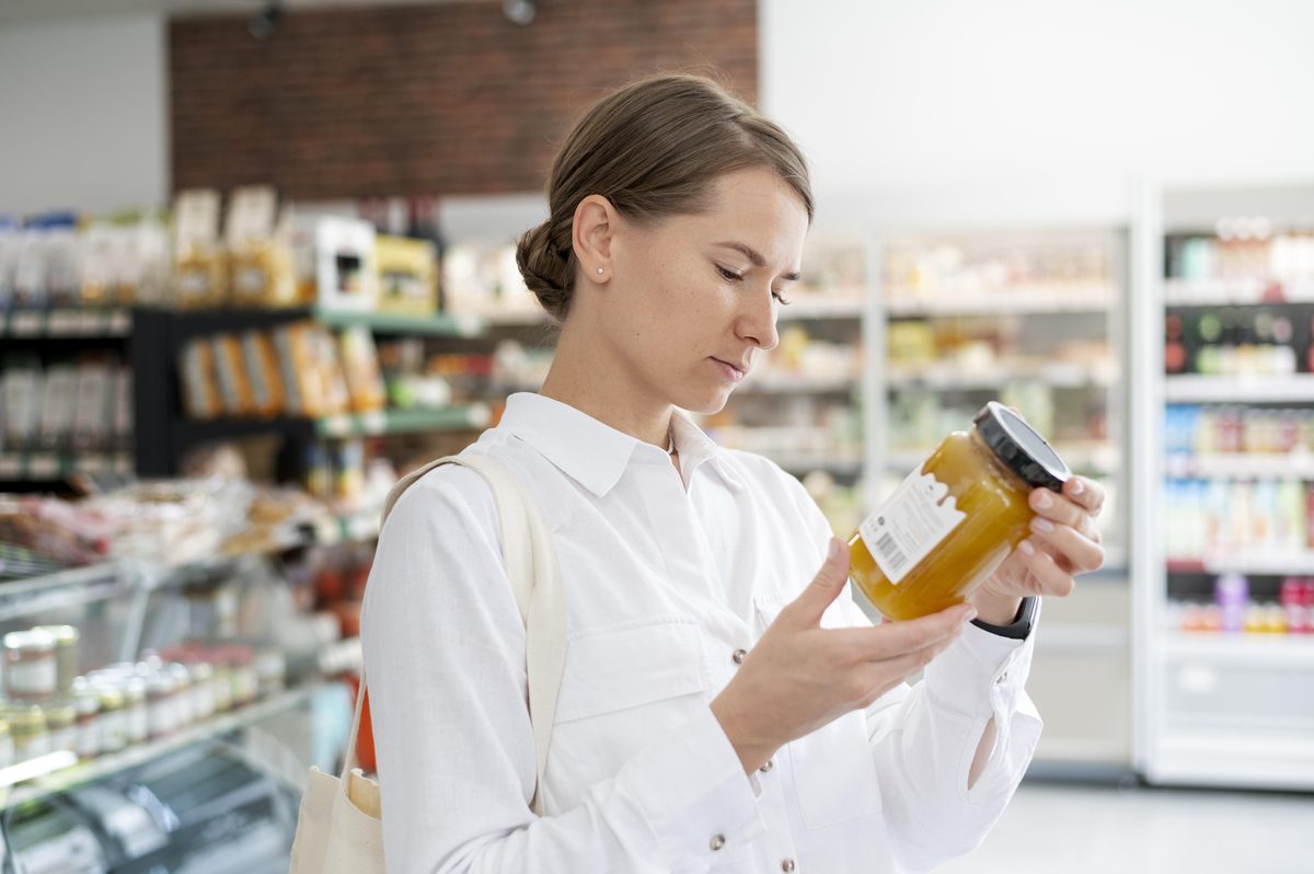 Woman reading the ingredients list of a product in a shop