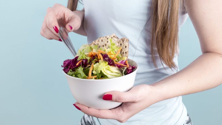Femme tenant un grand bol de salade de légumes