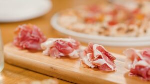 Fines tranches de jambon cru sur une planche de service en bois
