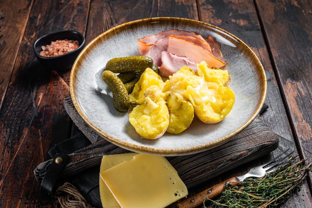 Melted raclette cheese over potatoes with ham