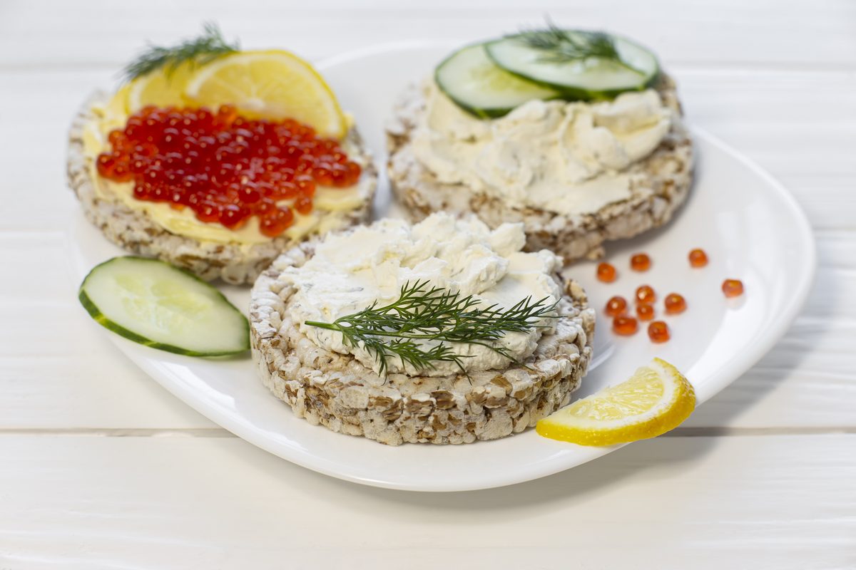 Rice cakes topped with salmon roe, soft cheese and cucumber