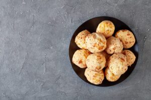Gougères au fromage sur assiette noire, vue de dessus