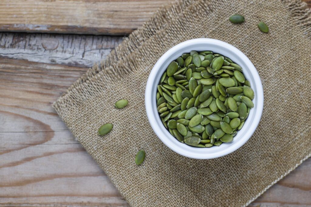 Pumpkin seeds in a bowl on hessian