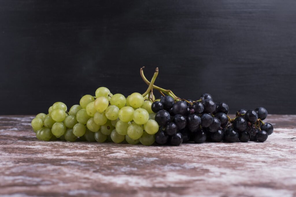 Bunches of white and black grapes on a table