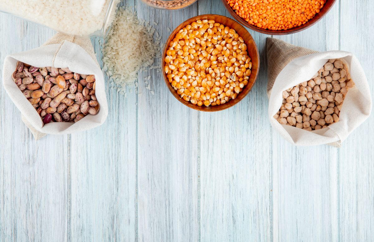 Beans, chickpeas, red lentils and dried maize in bags and bowls