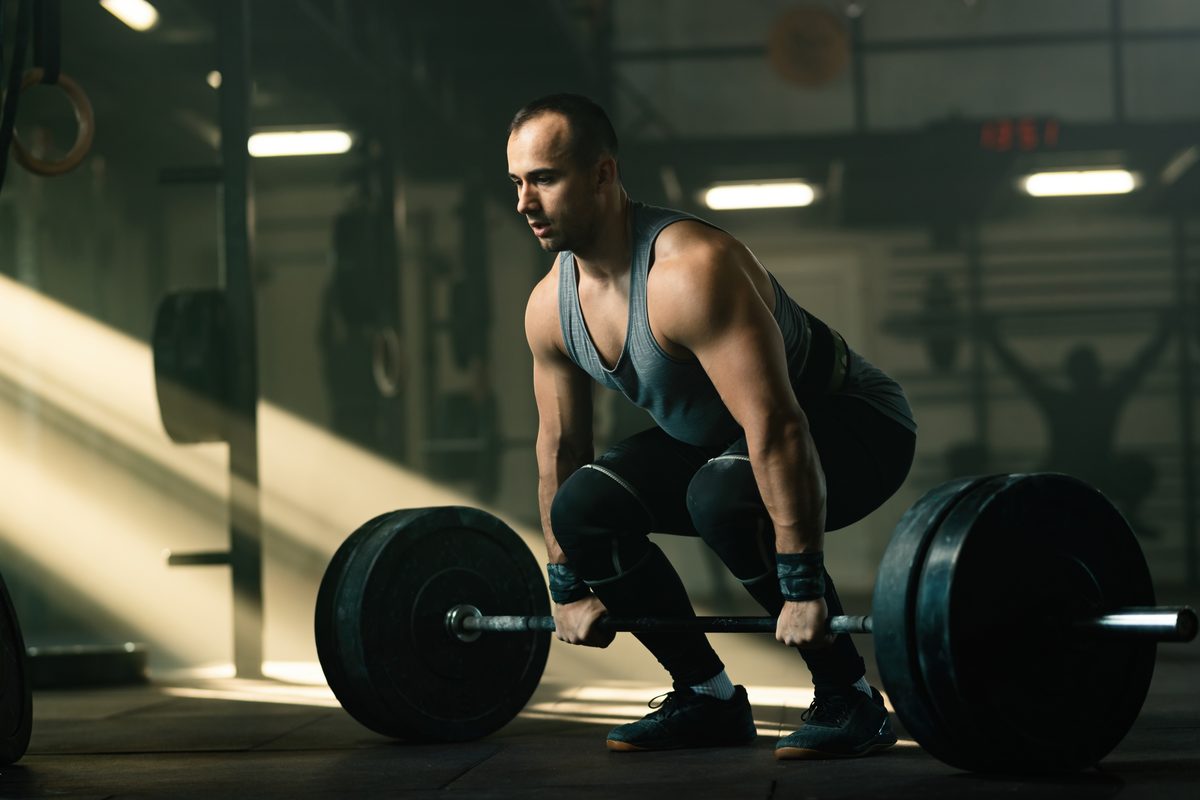 Homme soulevant une barre de musculation dans une salle de sport