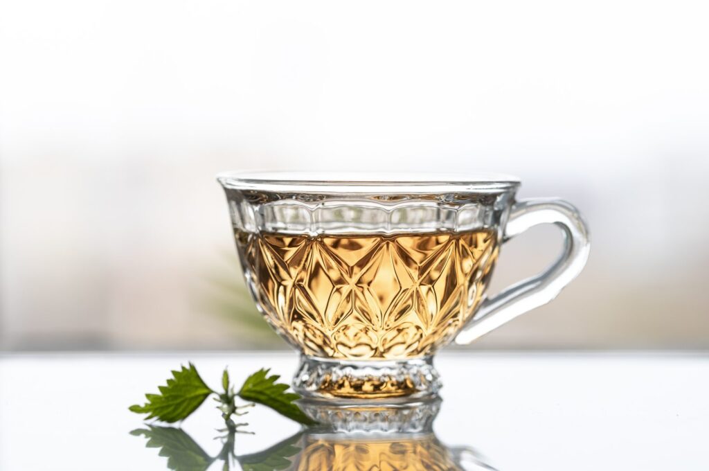 Infusion of young nettle leaves in front of a window
