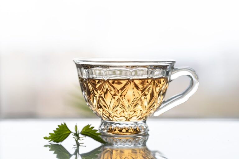 Infusion of young nettle leaves in front of a window