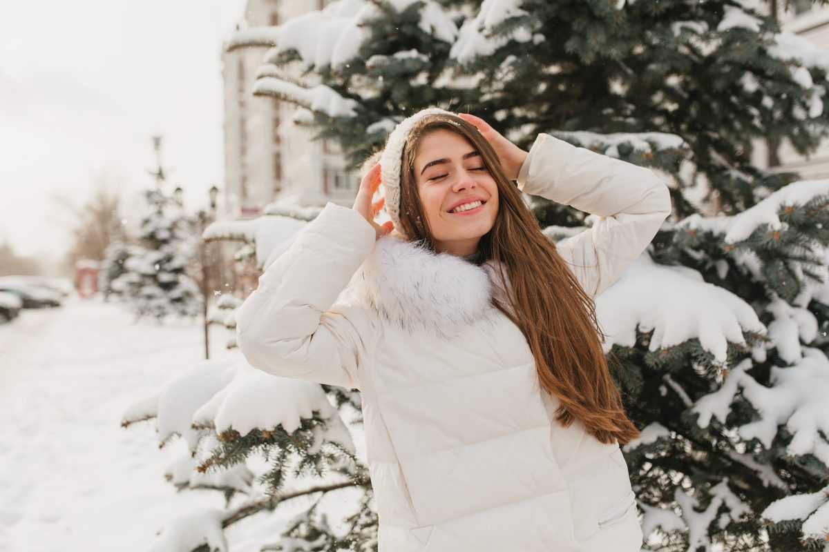 Young woman smiling in the sun in a snowy landscape