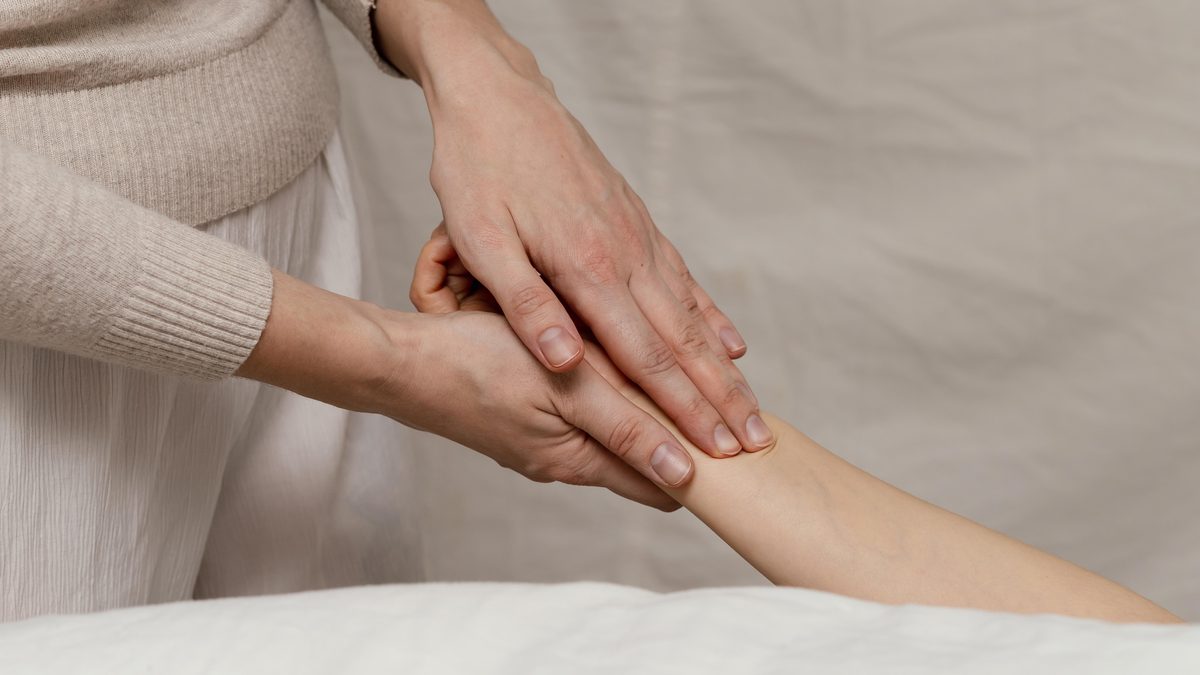 Mains d'une praticienne massant la main d'une patiente