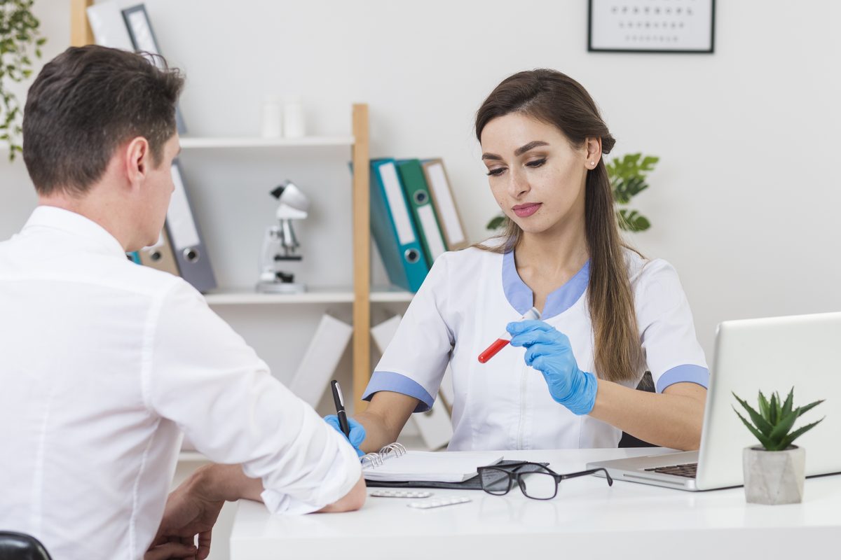 Médecin qui examine un tube de sang face à son patient