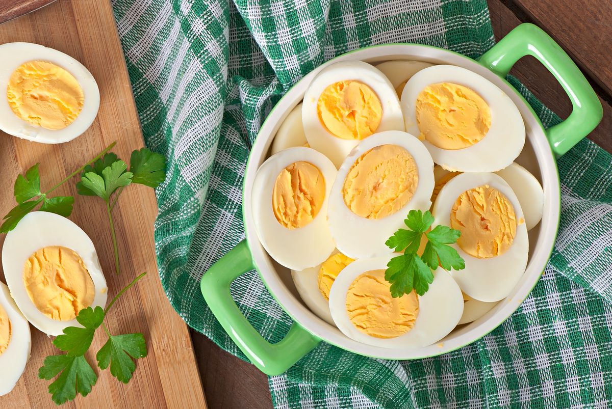 Hard-boiled eggs halved on a green dish with parsley