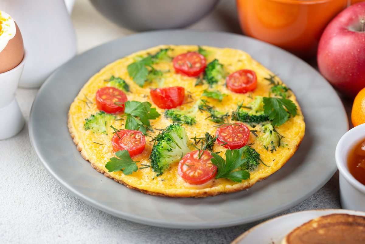 Omelette aux tomates cerises et brocoli dans une assiette grise