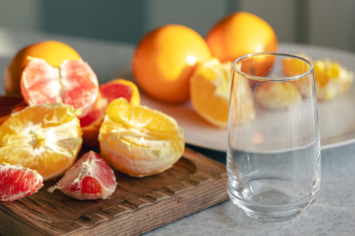 Peeled oranges and grapefruits in segments on a wooden board