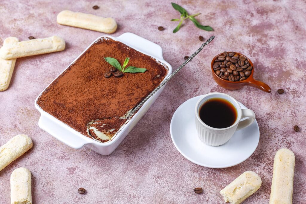 Slice of tiramisu dusted with cocoa on a ceramic plate
