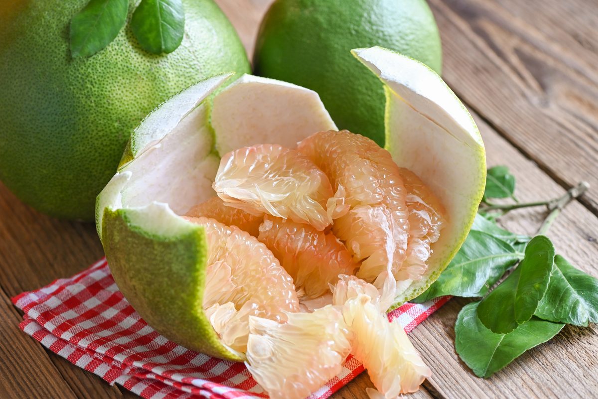 Pomelo opened in its green rind on a checked tablecloth