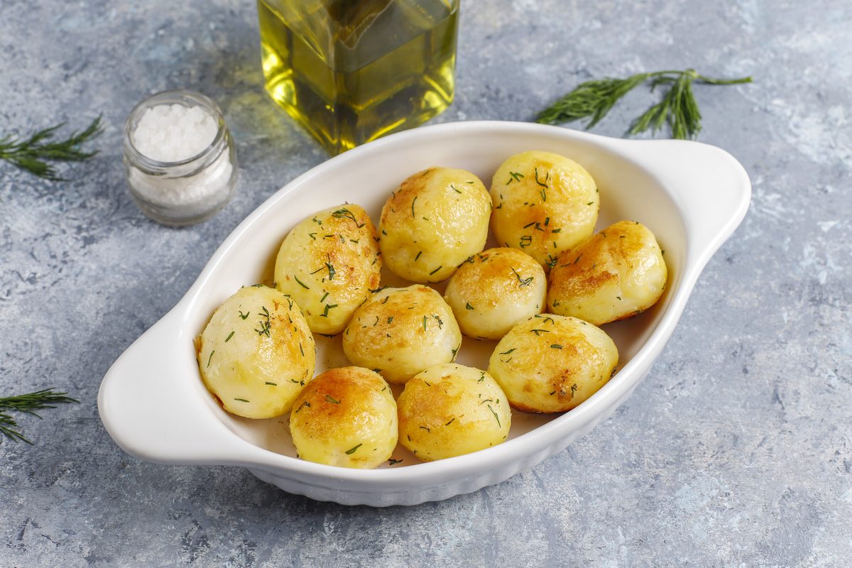 New potatoes roasted with dill in a white dish