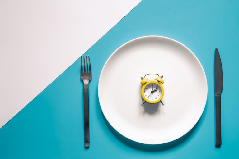 Réveil posé dans une assiette entre un couteau et une fourchette