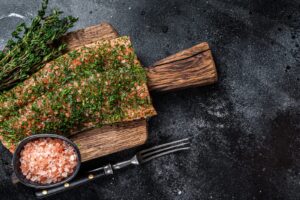 Gravlax salmon cured with dill and salt on a wooden board