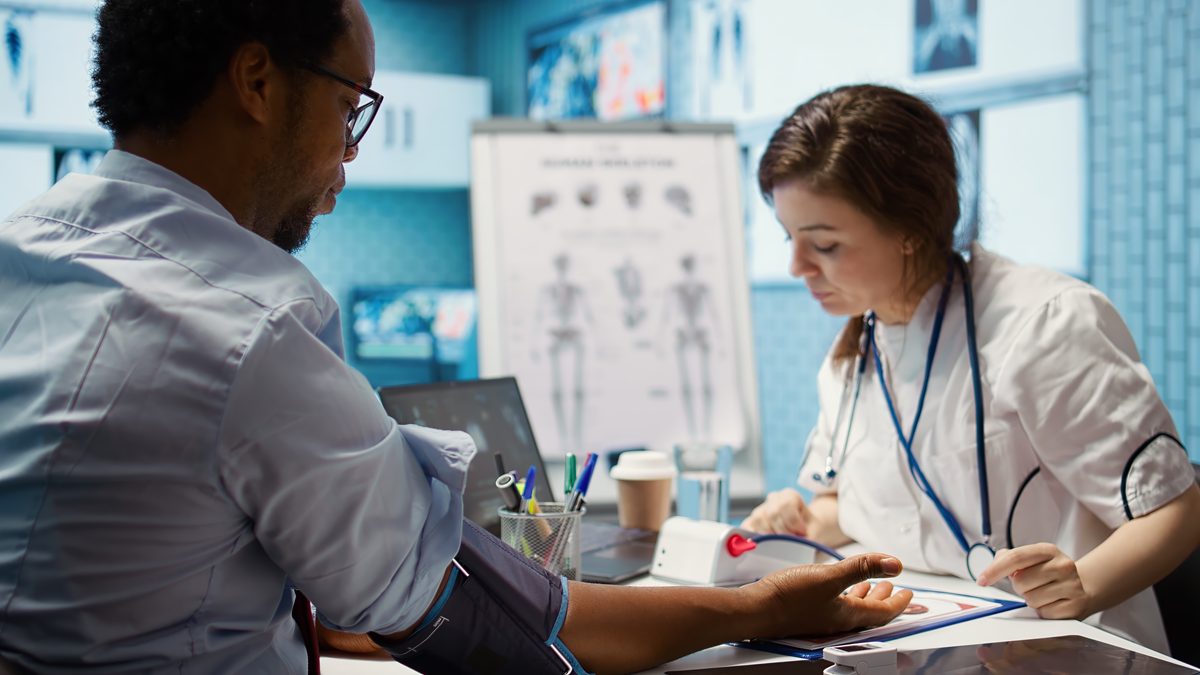 Nurse measuring a man's blood pressure at the surgery