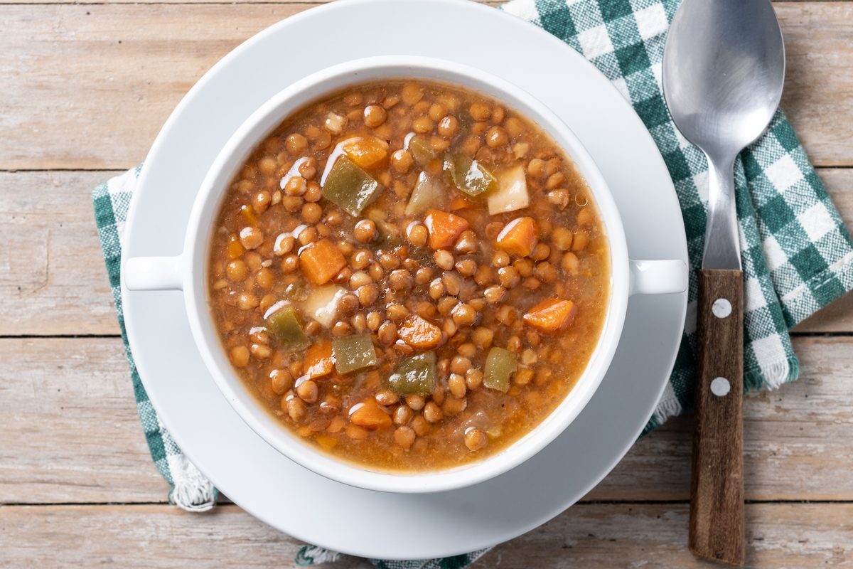 Lentil and vegetable soup served in a bowl with handles