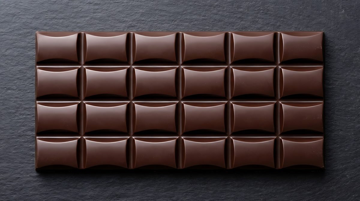 Whole bar of dark chocolate resting on a slate board