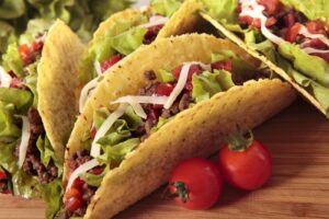 Tacos au bœuf garnis sur une table en bois