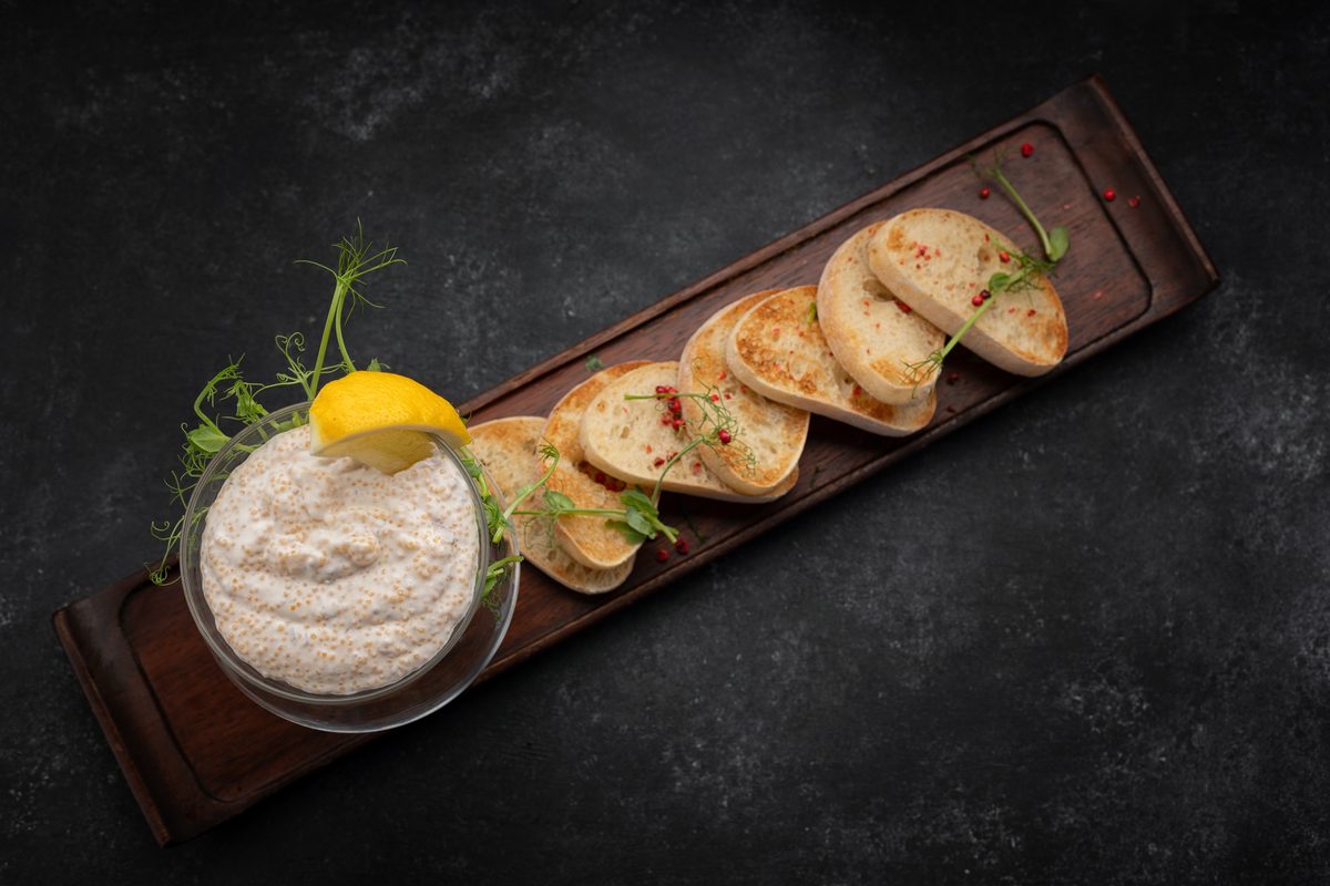 Pike roe spread in a small glass jar, served with toast and lemon