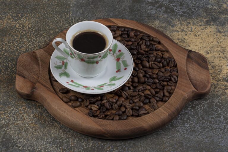 Cup of espresso and coffee beans on a wooden board