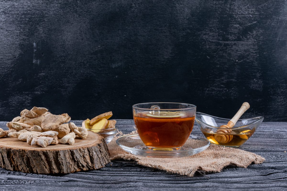 Cup of ginger tea with slices of ginger and honey