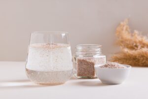 Verre d'eau et tégument de psyllium posés sur une table