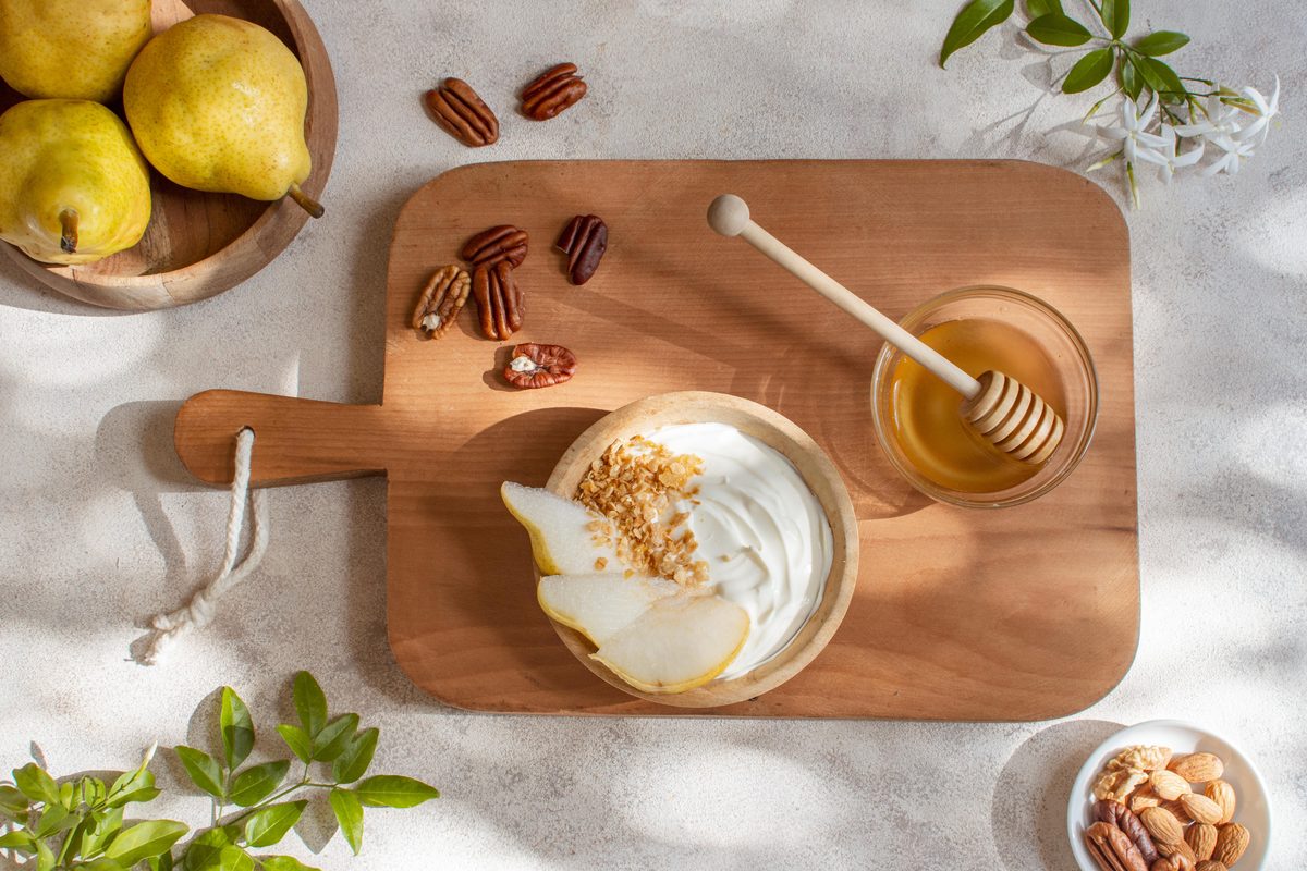 Pear and granola yoghurt served with a small pot of honey