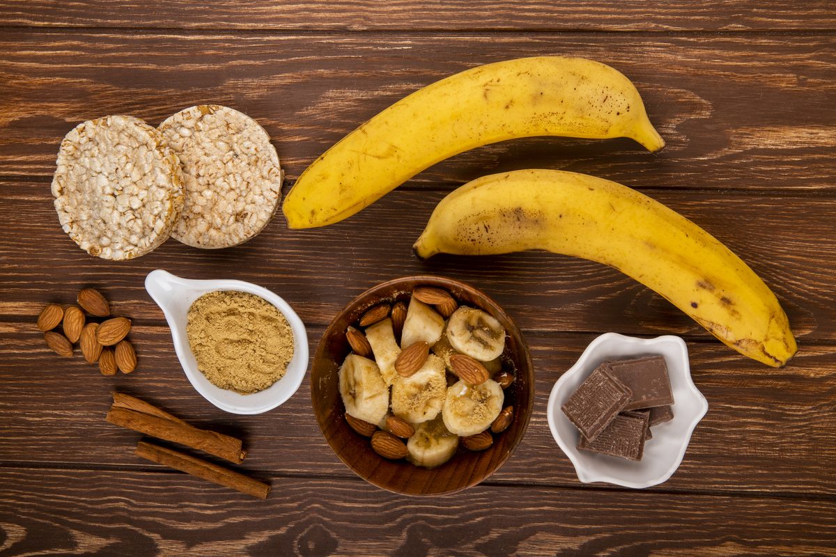 Bananas, almonds, rice cakes and dark chocolate on a wooden table
